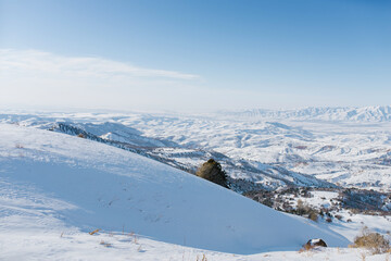 Picturesque Tien Shan mountains in Uzbekistan, covered with snow, winter clear Sunny day in the mountains. Amazing panorama in Beldersay