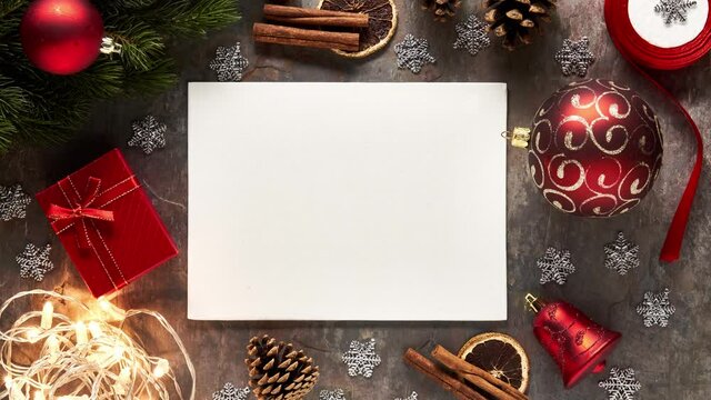 White blank sheet for Merry Christmas message with red xmas decorations. Horizontal top view 4K stop motion/timelapse video. Holiday greeting social media card concept. Can be slowed down/speeded up.