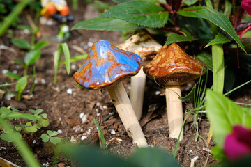Ceramic mushroom ornaments in a garden setting part of a fairy garden