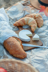 Nice picnic by the lake. Hot tea, thermos, blanket, croissants, cheese, fruits, pumpkins. Beautiful autumn decor.