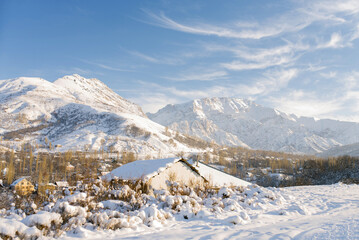 Chimgan mountain in winter on a Sunny frosty day in Uzbekistan and a snow covered house
