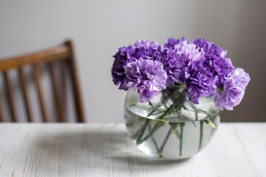 Bridal bouquet of lilac carnations in a round glass vase Bridal bouquet of lilac carnations in a round glass vase as table decoration