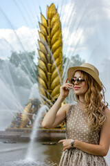 Beautiful girl in a beige dress poses for the camera, tourism in Moscow in the summer.