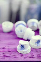 The soiled blue nozzles from the paint sprayer lies on a purple plank on a background of a many...