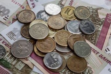 Paper rubles and coins are in a heap. Unstable exchange rate and crisis. Close-up.