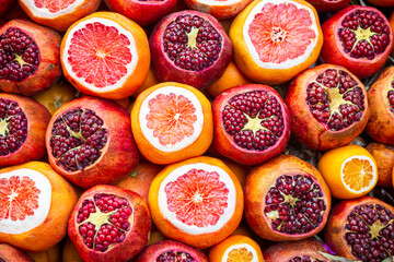 Cut oranges and pomegranates at a fruit stand. Healthy organic food is rich in vitamin c, responsible for strong immune system.