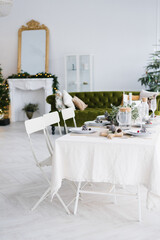 Christmas holiday beautifully set table in a spacious bright dining room or living room in the house
