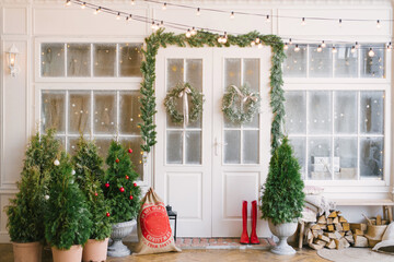 Winter rustic interior decorated for New year with Christmas trees. Winter exterior of a country house with Christmas decorations in rustic or classic style. Christmas eve