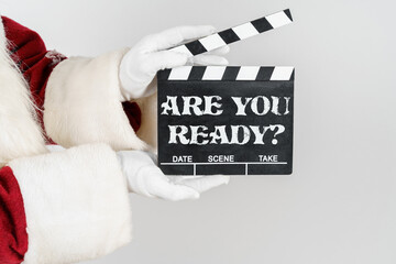 Santa Claus is holding a cracker in his hands - a numerator with the text - ARE YOU READY