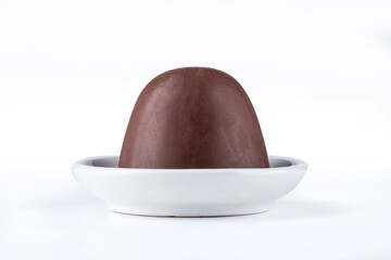 Chocolate truffle with delicious filling isolated on white background. Closeup photography.