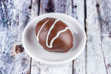 Chocolate truffle with green grape filling isolated on white background. Closeup photography.