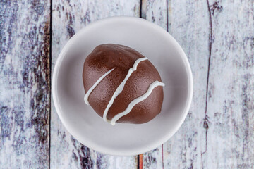 Chocolate truffle with green grape filling isolated on white background. Closeup photography.