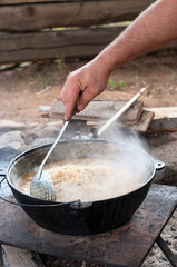 Male hand mixing rice with slotted spoon. Rice pilaf cooking series