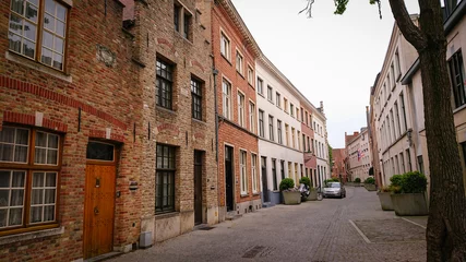 Fototapeten Bruges, Belgium - May 12, 2018:  Roofs And Windows Of Old Authentic Brick Houses On Street Ontvangers-straat © CuteIdeas