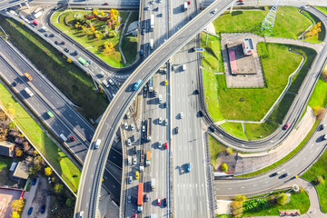 Aerial drone view of road interchange or highway intersection with busy urban traffic in modern...