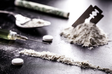 cocaine and heroin on dark wooden table, concept of addiction and chemical dependency, illegal drugs