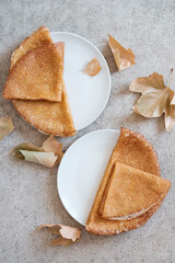 Pancakes in white plates on gray background