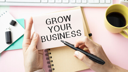 Grow your business words on office table with computer, coffee, notepad, smartphone and digital tablet