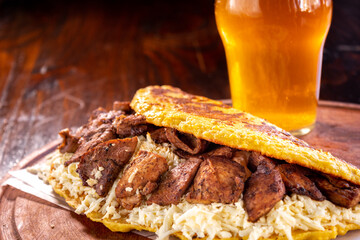 Venezuelan cachapa with pork and a glass of beer