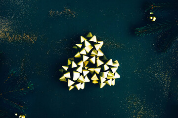 Christmas background. Golden bowknots on dark green background.