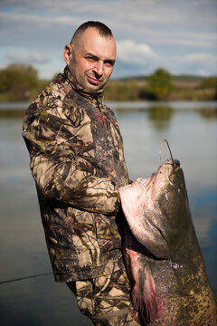 Fisherman holding a giant catfish. Catch of fish, freshwater fishing, monster fish