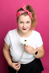 Young woman pose with flowers on pink backgound