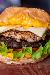 Big hamburger with a glass of beer in the background 