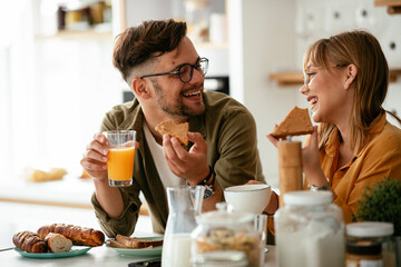Young couple making sandwich at home. Loving couple enjoying in the kitchen