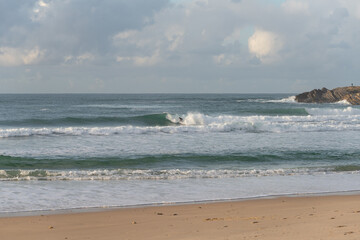 Surfers surfing in Baleal Island beach atlantic ocean waves in Peniche, Portugal