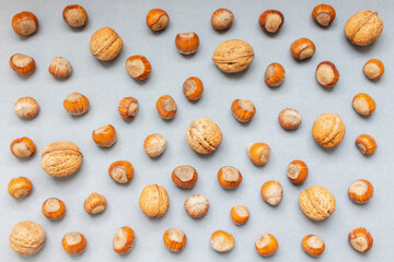Nut and walnut pattern on gray background, top view.