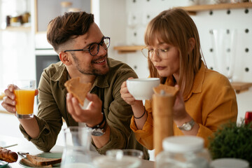 Young couple making sandwich at home. Loving couple enjoying in the kitchen