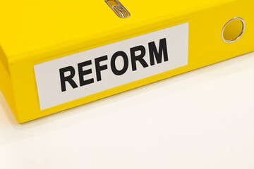The word reform on a white background with a yellow folder. Business concept