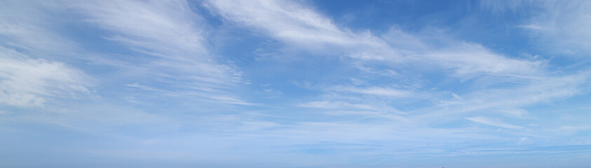 Blue sky with wispy clouds. Panoramic sky background.