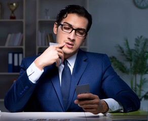 Young business playing cards late in office