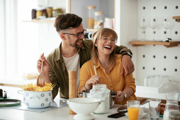 Husband and wife in kitchen. Young couple preparing delicious food at home..