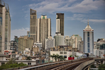 Fototapeta na wymiar This unique photo shows the skyline of Bangkok in Thailand including the skytrain railroad track in the foreground and the skyscrapers.