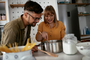 Husband and wife in kitchen. Young couple preparing delicious food at home..