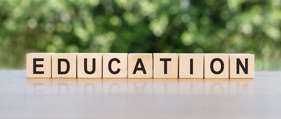 Education - word from wooden blocks with letters, concept of teaching or learning in school or college, on the table.