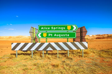 Directions road sign for Alice Springs and Pt Augusta in Coober Pedy town in Australia. Opal mining...