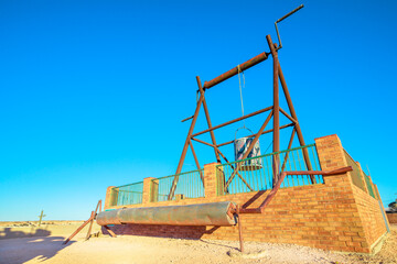 Well of old mines in the Big winch lookout of Coober Pedy town in Australia. Located in South Australia, outback desert. Monument of the machinery used to bring opals to the surface.