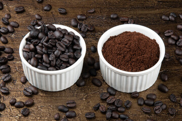 Roasted and ground coffee beans in white bowl. Rustic background.