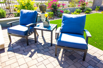 Two Arm Chairs With Blue Cushions & Small Table On Rear Patio Pavers