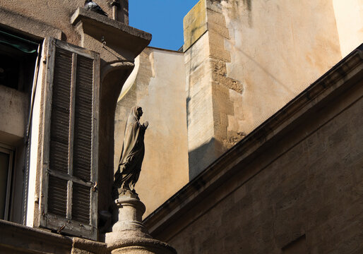 praying statue on the corner of an old building