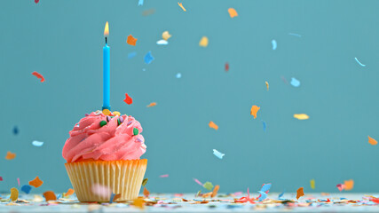 Delicious Cupcake with colorful candles on pastel blue background