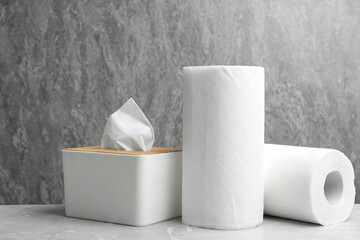 Rolls of paper towels and tissues on marble table