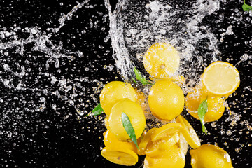 Freeze motion of fresh lemons with splashing water isolated on black background