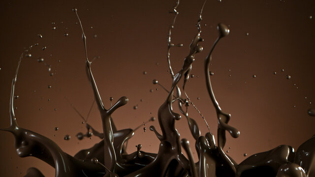 Splash of molten chocolate on gradient brown background, cllose-up.