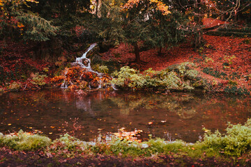 Small waterfall with autumn foliage in the park of Monza