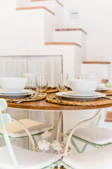 Table setting. Plates are beautifully placed on a festive home table. Dinner dishes and glasses