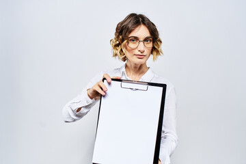 Naklejka premium Business woman with a folder of white documents in her hand on a light background And hairstyle glasses model